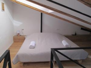 een slaapkamer met een wit bed op zolder bij Cozy Loft in Tbilisi City