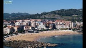 a view of a beach with a city in the background at Castro Sun And Beach in Castro-Urdiales