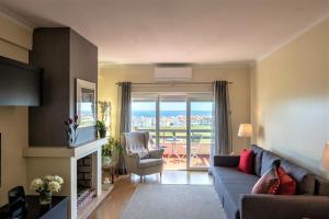 ein Wohnzimmer mit einem Sofa, einem Stuhl und einem Fenster in der Unterkunft Window to the Sea in Oeiras