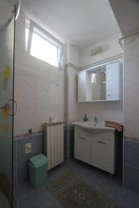 a bathroom with a sink and a toilet and a window at Apartmani Banina in Ika +55 photos
