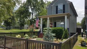 a house with a fence and an american flag at Vacation Home 5 Mins to Down Town 2 Bedrooms 2 Baths Garden Area Hot Tub in Nashville
