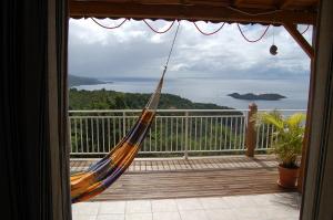 a hammock on a balcony with a view of the ocean at Gîtes la Marlyse in Bouillante