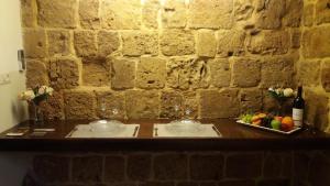 a table with two glasses and a plate of fruit at Lighthouse Suite - Acre in ‘Akko