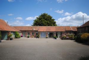 una fila de casas de ladrillo con techos rojos en The Old Dairy, Heritage Escapes, Field House Farm, en Bempton