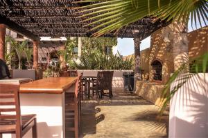 a patio area with tables, chairs, and umbrellas at Cerritos Beach Inn in El Pescadero