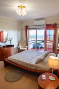 a bedroom with a large bed and a balcony at Window to the Sea in Oeiras