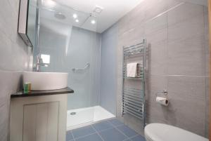 Un baño con lavabo, inodoro y ducha. en The Old Dairy, Heritage Escapes, Field House Farm, en Bempton