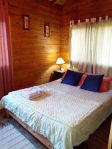 Un dormitorio con una cama grande en una habitación de madera. en Cabaña mandala, en Tigre