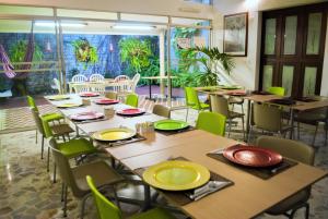 a room with tables and chairs with yellow plates on them at Hotel Casa Santa Monica Norte in Cali
