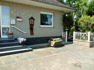 a house with a porch and a window and a flower pot at Achtern Diek in Lembruch