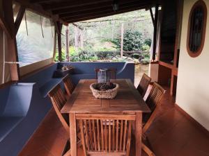 a dining room with a wooden table and chairs at Casa d'Olívia in Porto da Cruz