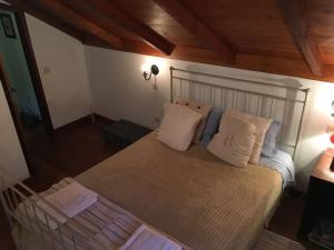 a bedroom with a large bed with pillows on it at Casa d'Olívia in Porto da Cruz