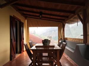a wooden table and chairs in a room with a window at Casa d'Olívia in Porto da Cruz