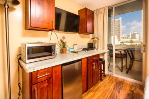 a small kitchen with a microwave and a table at Castle Waikiki Grand Hotel in Honolulu