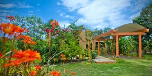 un jardín con cenador y flores en VILLA ANACAHUITA, Limonal, en Jarabacoa