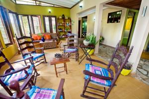 een kamer met schommelstoelen en een woonkamer bij VILLA ANACAHUITA, Limonal in Jarabacoa