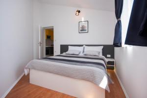 a bedroom with a large bed in a white room at Heavenly bay in Šibenik