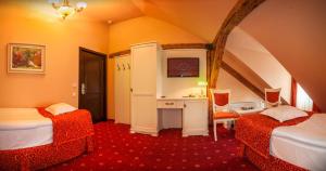 a room with two beds and a desk and a television at Hotel Central Park Sighisoara in Sighişoara