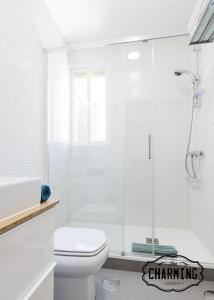 a white bathroom with a shower and a toilet at Charming Atocha in Madrid