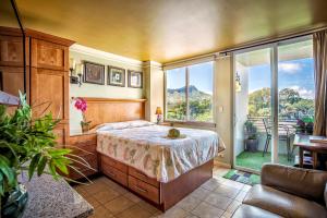 ein Schlafzimmer mit einem Bett und einem großen Fenster in der Unterkunft CASTLE at Waikīkī Grand in Honolulu