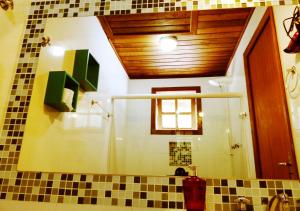 a bathroom with a shower with a mirror and a sink at Pousada Encontro dos Rios in Lumiar