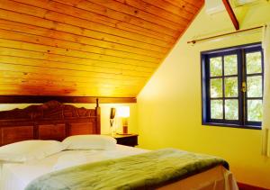 a bedroom with a large bed with a wooden ceiling at Pousada Encontro dos Rios in Lumiar