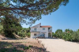 a large white house with a car parked in the driveway at Heavenly bay in Šibenik