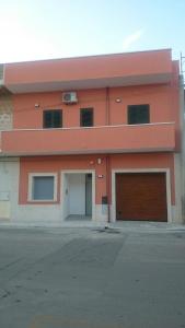 an orange building with two garage doors in front at La dimora di Vituccio B&B in Avetrana
