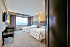 a hotel room with two beds and a window at Barceló Mexico Reforma in Mexico City