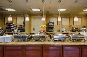 una cocina con sartenes de acero inoxidable en West Inn & Suites, en Carlsbad