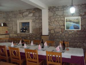 a dining room with a table and chairs with pink napkins at Guest House Fosa in Opuzen