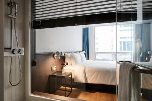 a bedroom with a bed and a window with a shower at Hotel NewV in Seoul