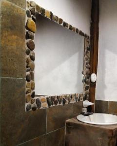 bagno con specchio con rocce sul muro di Cinnamon House a Mindo