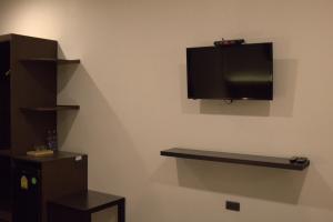 een flatscreen-tv aan de muur van een kamer bij Paklop Resort in Lop Buri