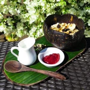 a green plate with a bowl of food on a table at Blue Marine Resort in Gili Air