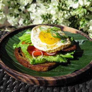 a breakfast sandwich with an egg on a banana leaf at Blue Marine Resort in Gili Air