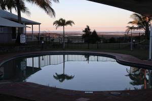 a pool of water with a view of a beach at Illawong Beach Resort in Mackay
