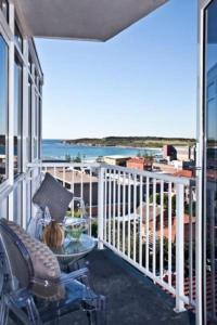 a balcony with a table and chairs and the ocean at Stunning Ocean View Apartment !!! in Sydney