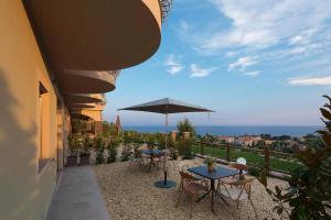 patio z dwoma stołami i parasolem w obiekcie Villa LeA w mieście Imperia