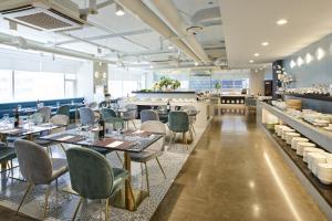 a restaurant with tables and chairs and a bar at Hotel NewV in Seoul