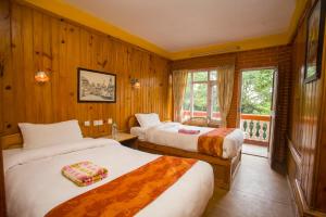 ein Hotelzimmer mit zwei Betten und einem Fenster in der Unterkunft Langtang View Nagarkot Bed and Breakfast in Nagarkot