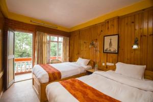 ein Hotelzimmer mit zwei Betten und einem Fenster in der Unterkunft Langtang View Nagarkot Bed and Breakfast in Nagarkot + 37 Fotos