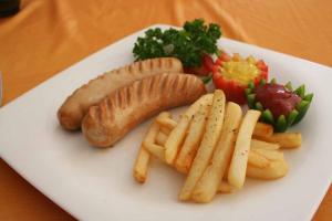 a white plate topped with a sandwich and fries at LK Emerald Beach - SHA Extra Plus in Pattaya North