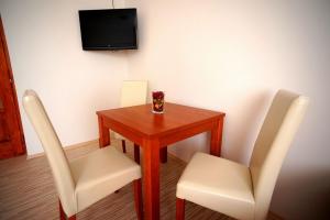 Pokój ze stołem, 2 krzesłami i telewizorem w obiekcie Borka Apartman w mieście Makó