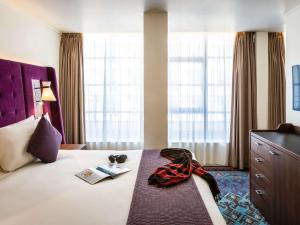 a bedroom with a bed and a dresser at Mercure London Bridge in London