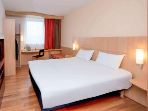 a large white bed in a hotel room at ibis Esch Belval in Esch-sur-Alzette