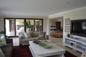 a living room with a couch and a table at Mahogany House - SOLAR POWERED in Ballito