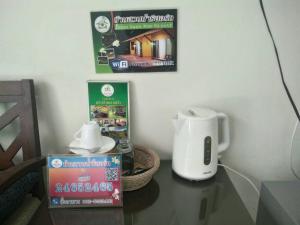 a table with a coffee maker and a picture of a house at Baan Suan Nam Resort in Don Sak