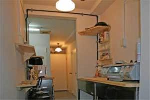 a kitchen with a counter and a door into a room at Hostel Zen in Yokohama
