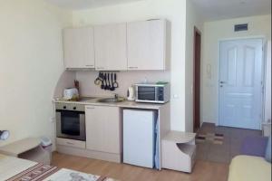 a kitchen with white cabinets and a microwave at Private Apartment in Marina View Fort Beach in Elenite